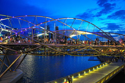 Illuminated ferris wheel against blue sky