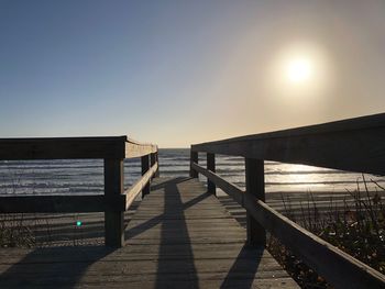 Scenic view of beach against clear sky at sunset