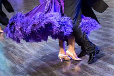 Low section of couple dancing on parquet floor