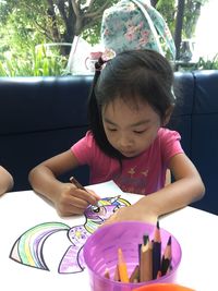 Cute girl coloring on paper