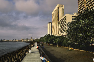Footpath amidst buildings in city against sky