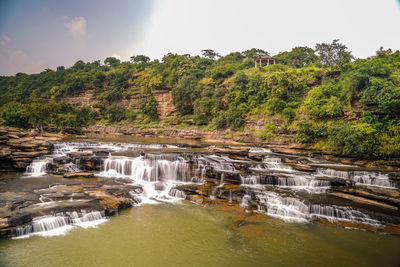 Scenic view of waterfall against sky