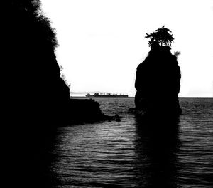 Silhouette woman standing by sea against clear sky