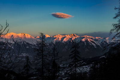 Scenic view of snowcapped mountains against sky at sunset