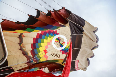 Low angle view of balloons hanging against sky