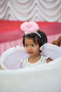 Innocent girl wearing angel costume wing