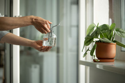Cropped hand of person pouring water in glass