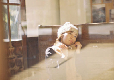 Portrait of cute girl looking through glass window