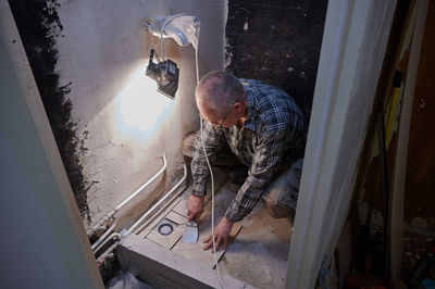 High angle view of man fixing bathroom