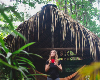 Woman drinking coffe after a night in jungle