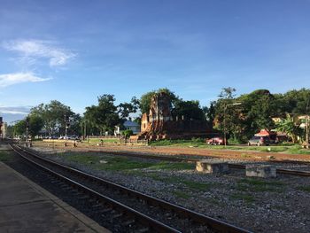 Railroad tracks by trees against sky