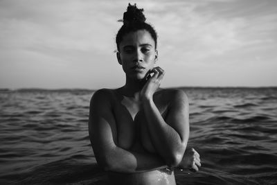 Portrait of young woman in sea against sky