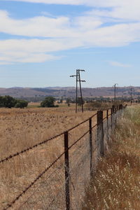 Fence on field against sky