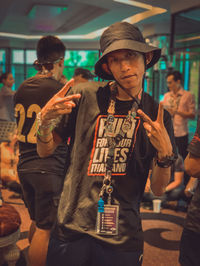 Young man holding camera while standing at music concert