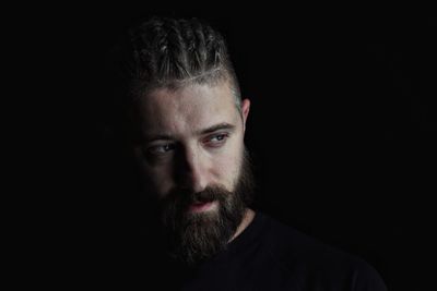 Portrait of man against black background