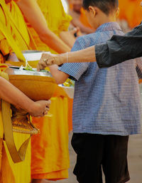 Low section of people standing against yellow