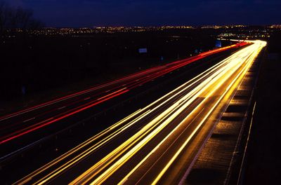 High angle view of light trails on two lane highway at night
