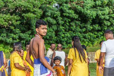 Rear view of friends standing against people