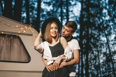 Smiling couple standing against motor home