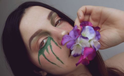 Close-up portrait of woman with pink flower