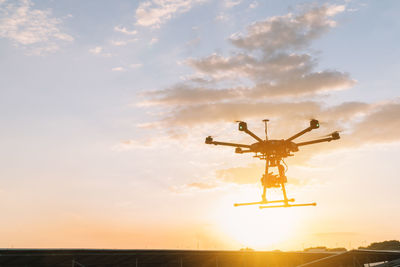Low angle view of communications tower against sky during sunset