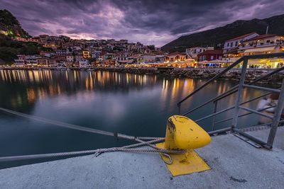 Boats moored in city against sky at night