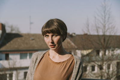 Portrait of teenage girl standing on bare tree