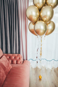 Low section of person holding balloons at home