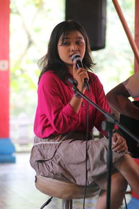 Young woman singing while sitting