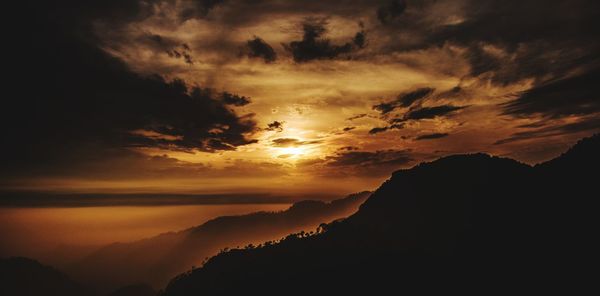 Scenic view of silhouette mountains against sky at sunset