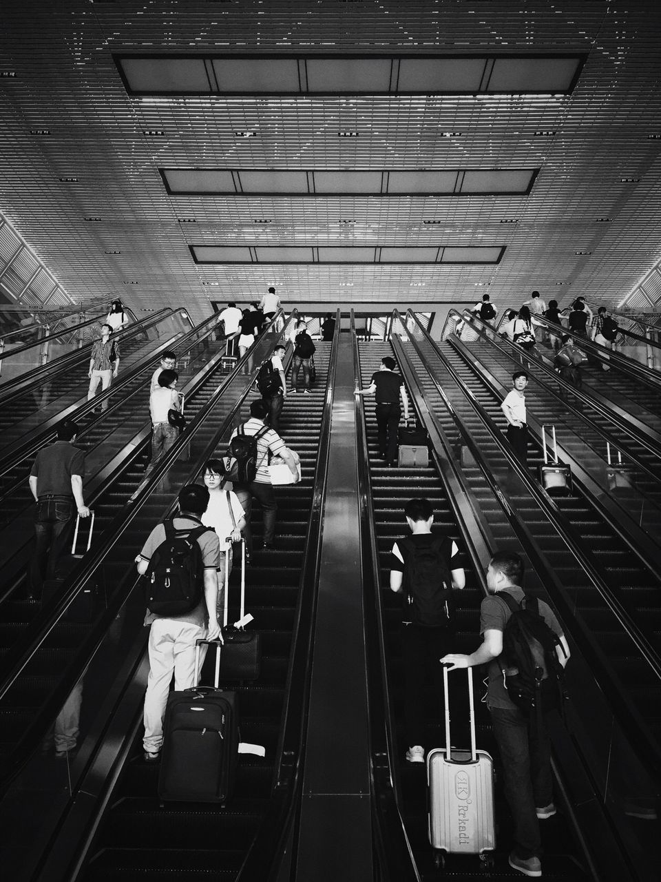 large group of people, indoors, men, transportation, high angle view, person, public transportation, illuminated, lifestyles, railroad station, travel, city life, leisure activity, rail transportation, subway station, escalator, mode of transport, railroad track, on the move