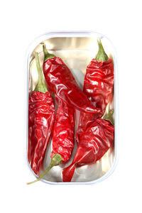 Close-up of red chili peppers on white background