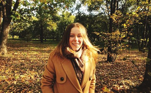 Portrait of smiling young woman standing in park