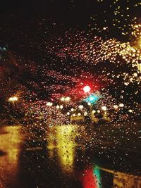 Illuminated city seen through wet window