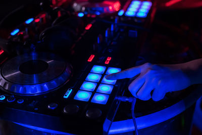 Close-up of woman playing music on audio equipment in nightclub