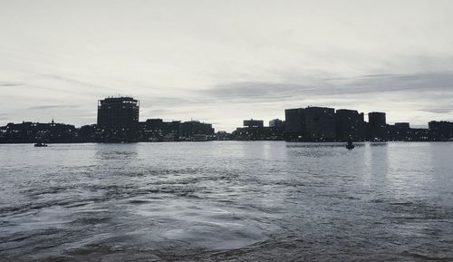 Buildings by sea against sky in city