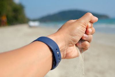 Close-up of hand on sand