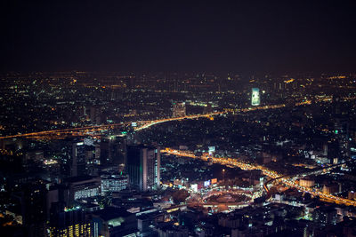 High angle view of illuminated cityscape against sky at night