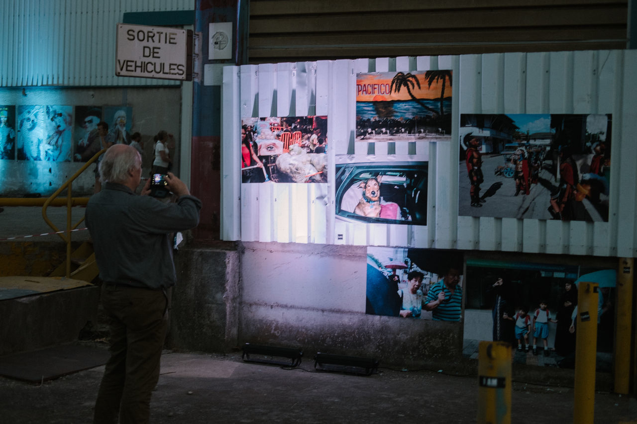 real people, men, window, leisure activity, communication, store, standing, full length, technology, built structure, lifestyles, day, architecture, one person, photographing, indoors, photograph, photography themes, adult, people