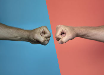 Close-up of man hand with tattoo against blue background