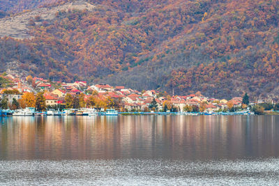 Scenic view of lake by buildings during autumn