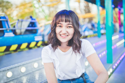 Beautiful asian girl in an amusement park, smiling. copy space.