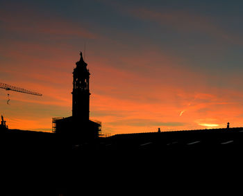 Silhouette of lighthouse against sky during sunset