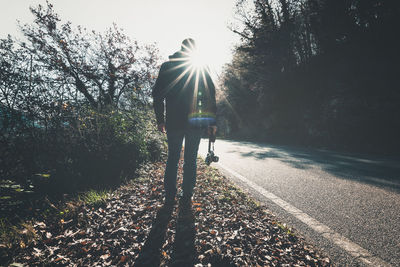 Rear view of man by trees against sky