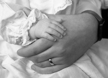 Close-up of couple holding hands on bed