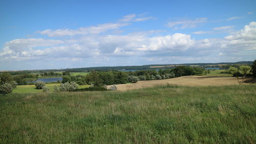 Scenic view of grassy landscape against cloudy sky