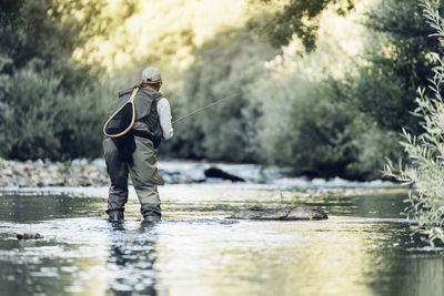 Man fishing in lake at forest