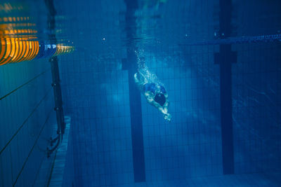 Woman swimming underwater in pool