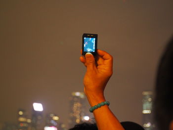 Close-up of hand holding smart phone at night