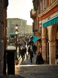 People walking on street amidst buildings in city